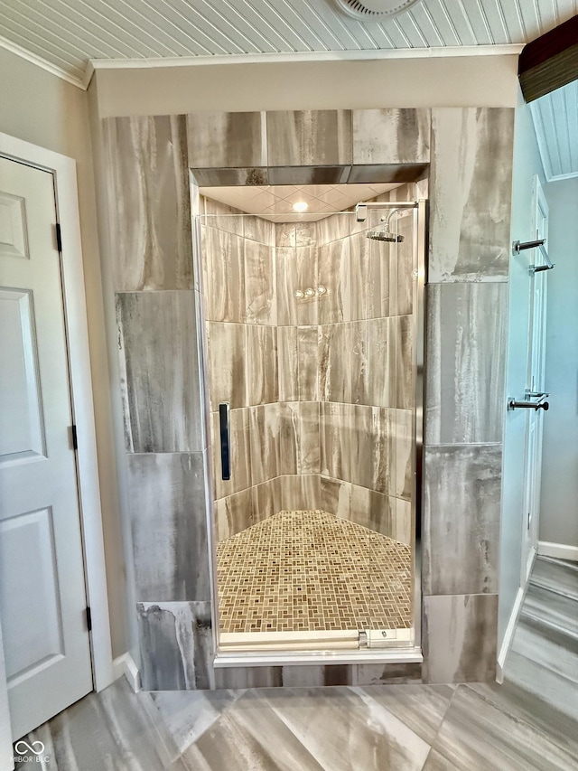 full bath with a shower stall and crown molding