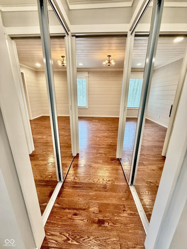 hall with wood walls and hardwood / wood-style flooring