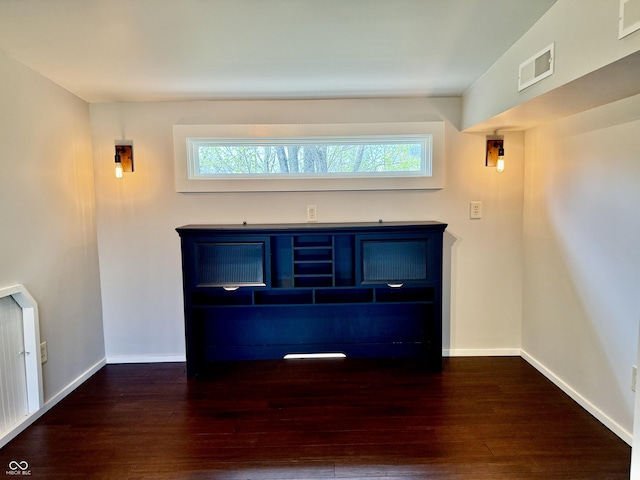 details with radiator, visible vents, wood finished floors, and baseboards