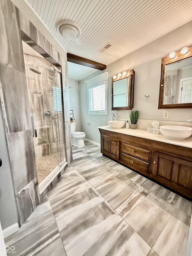 bathroom with a shower stall, a sink, double vanity, visible vents, and toilet