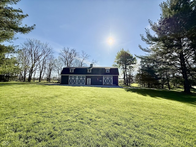 back of house featuring a barn, an outdoor structure, and a lawn