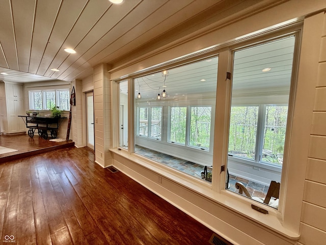 interior space featuring wood-type flooring, recessed lighting, visible vents, and baseboards