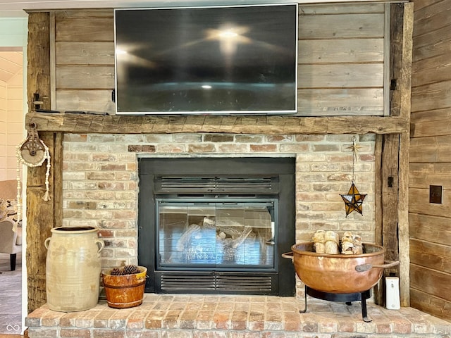 interior details featuring a brick fireplace and wood walls