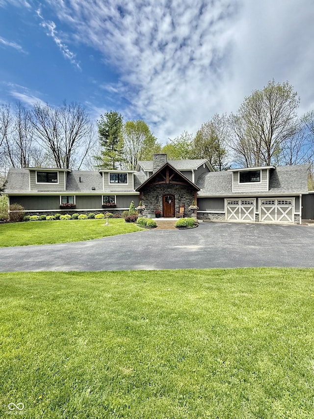 view of front of home with aphalt driveway, a front lawn, and roof with shingles