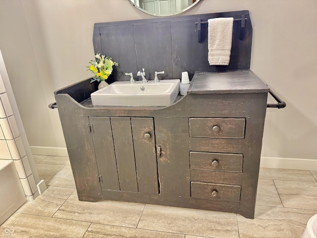 bathroom featuring baseboards, tile patterned flooring, and vanity