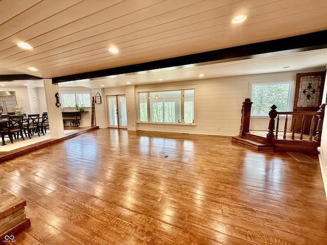 unfurnished living room with a healthy amount of sunlight and wood-type flooring