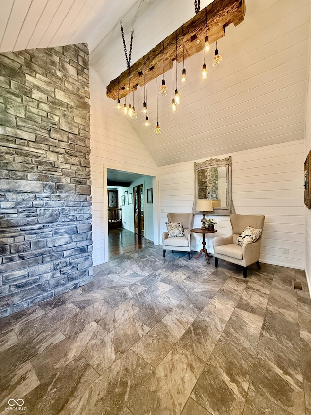 living area featuring wood walls, stone finish floor, beam ceiling, and high vaulted ceiling