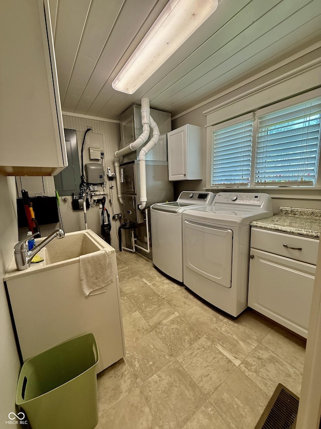 laundry area featuring wooden ceiling, separate washer and dryer, and cabinet space