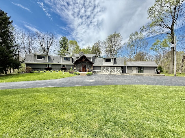 view of front facade featuring a chimney, aphalt driveway, a front lawn, and roof with shingles