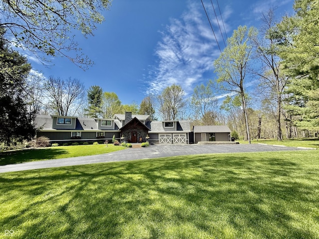 view of front of property featuring a front lawn, driveway, and a shingled roof
