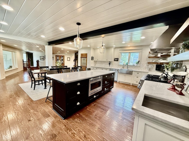 kitchen featuring stainless steel appliances, hardwood / wood-style flooring, a kitchen island, and a sink