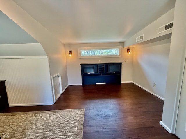 unfurnished living room with baseboards, visible vents, and wood-type flooring