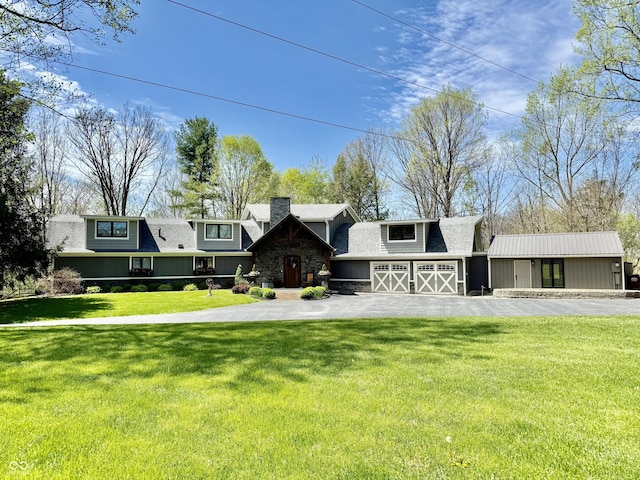 view of front of property with driveway, a chimney, a shingled roof, a front yard, and a garage