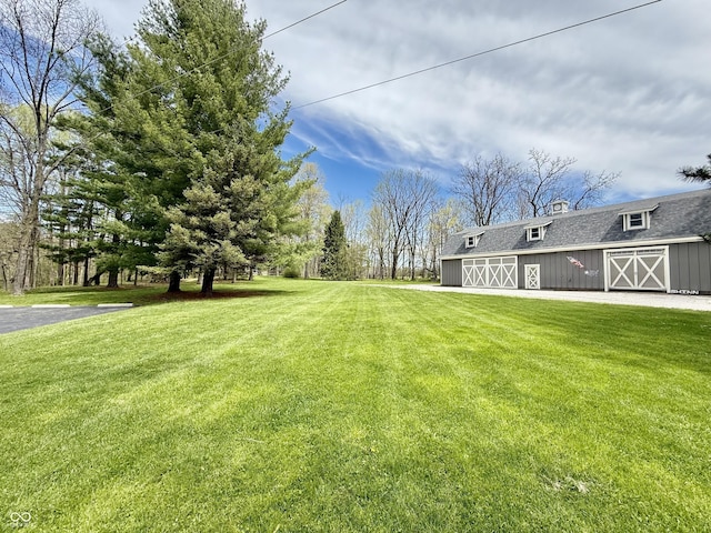 view of yard featuring an outdoor structure, a garage, and a barn