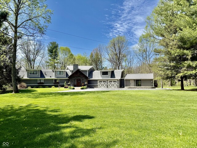back of house featuring a yard, a garage, and a chimney