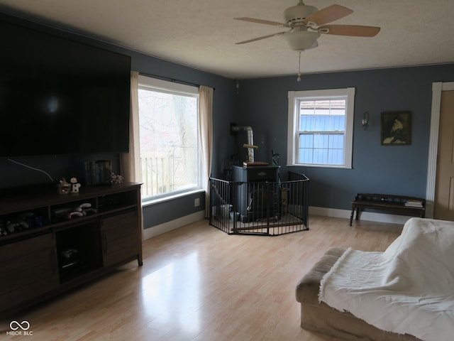 interior space featuring ceiling fan, light wood-style floors, and baseboards