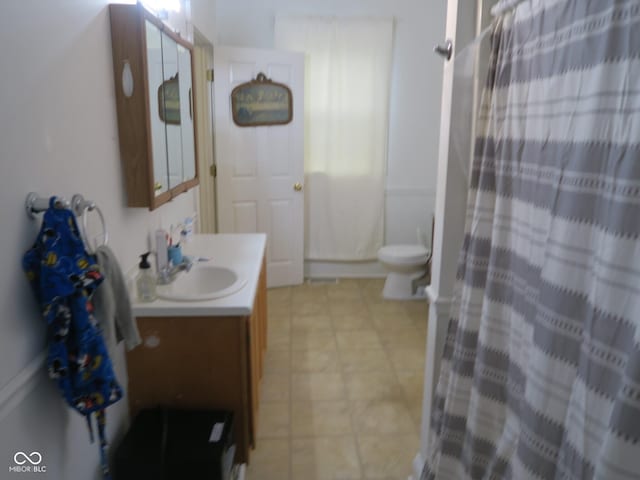 full bath featuring toilet, vanity, and a shower with curtain