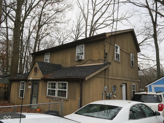 chalet / cabin featuring cooling unit and roof with shingles