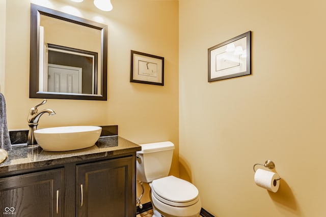 half bath featuring vanity and toilet