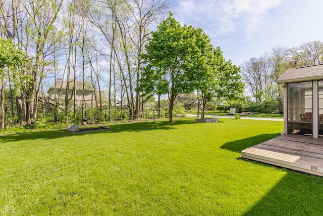 view of yard featuring a sunroom and a deck
