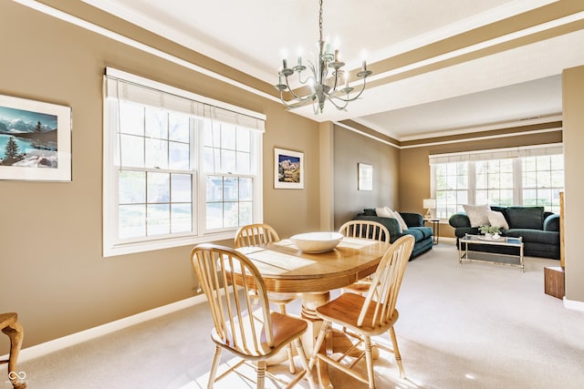carpeted dining space featuring crown molding, baseboards, and a chandelier