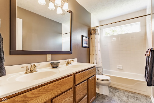 bathroom featuring a sink, an inviting chandelier, shower / bath combo, and toilet