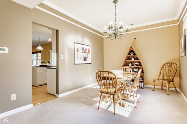 dining area with crown molding, a notable chandelier, and light colored carpet
