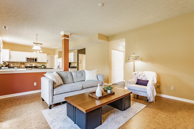 living room with baseboards, a textured ceiling, and visible vents