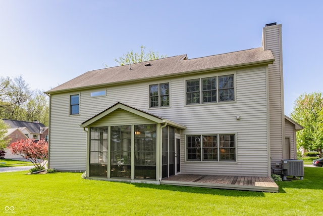 rear view of property with central AC, a deck, a chimney, a sunroom, and a yard