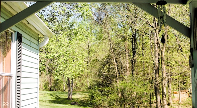 exterior space featuring a yard and a wooded view
