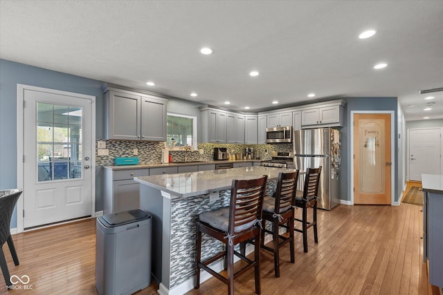 kitchen featuring light wood-style floors, gray cabinets, appliances with stainless steel finishes, and visible vents
