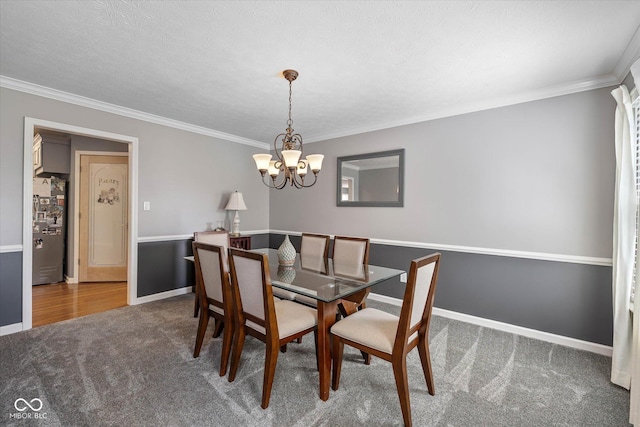 carpeted dining room with baseboards, an inviting chandelier, and ornamental molding