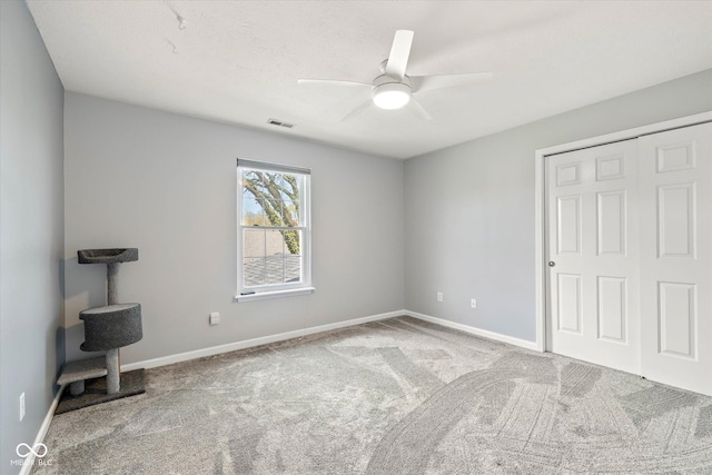 unfurnished bedroom featuring a closet, visible vents, baseboards, a ceiling fan, and carpet