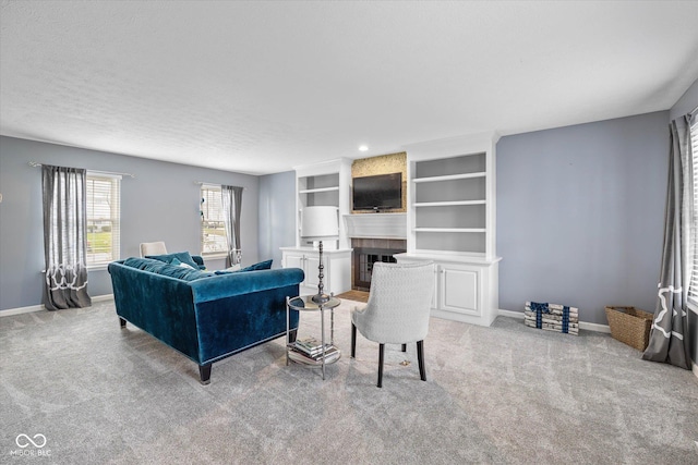 living room with light colored carpet, baseboards, and a large fireplace