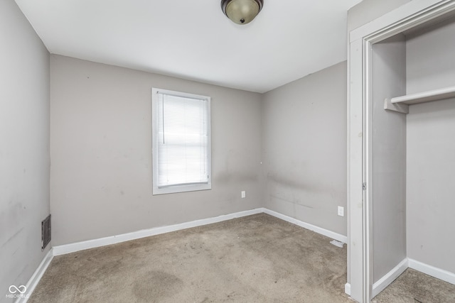 unfurnished bedroom with carpet floors, baseboards, and visible vents