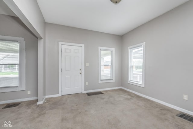foyer with baseboards, carpet flooring, and visible vents