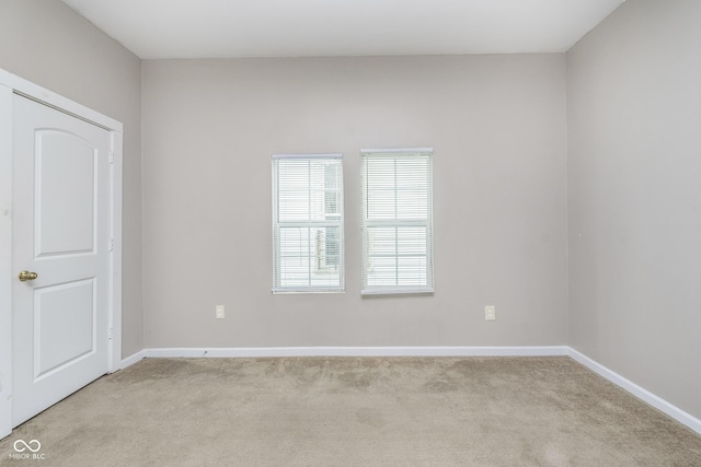 empty room with baseboards and light carpet