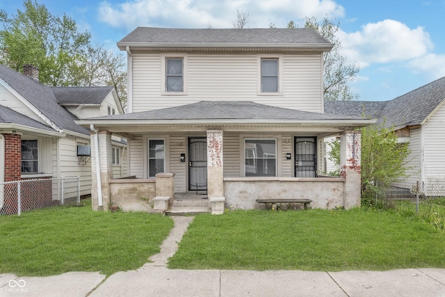 view of front of property featuring covered porch, fence, and a front yard