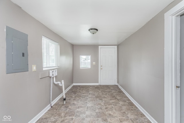 interior space featuring baseboards, electric panel, and stone finish floor