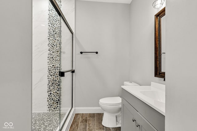 257 N Tacoma Ave, Indianapolis, IN 46201 - full bathroom featuring a stall shower, wood tiled floor, baseboards, toilet, and vanity