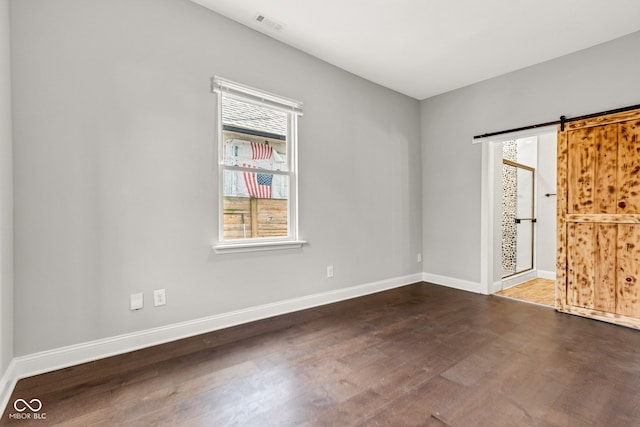 257 N Tacoma Ave, Indianapolis, IN 46201 - unfurnished room with baseboards, a barn door, and wood finished floors