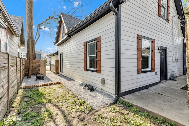 257 N Tacoma Ave, Indianapolis, IN 46201 - view of side of property featuring roof with shingles, fence, and a patio