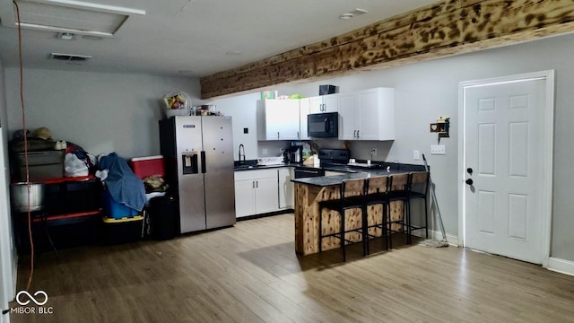 257 N Tacoma Ave, Indianapolis, IN 46201 - kitchen featuring a peninsula, light wood-type flooring, black appliances, and a sink