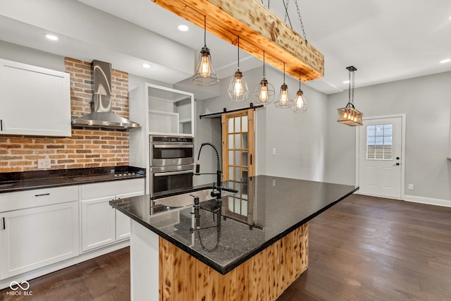 257 N Tacoma Ave, Indianapolis, IN 46201 - kitchen featuring a barn door, a sink, wall chimney range hood, double oven, and dark wood-style floors