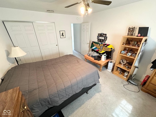carpeted bedroom featuring visible vents, a ceiling fan, and a closet