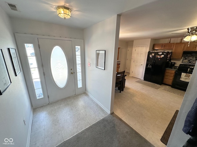 foyer entrance with visible vents, plenty of natural light, a ceiling fan, and baseboards