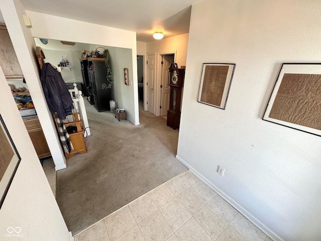 hallway with light carpet and baseboards