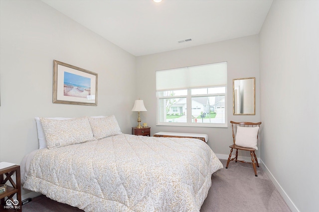 bedroom with baseboards, visible vents, and light colored carpet