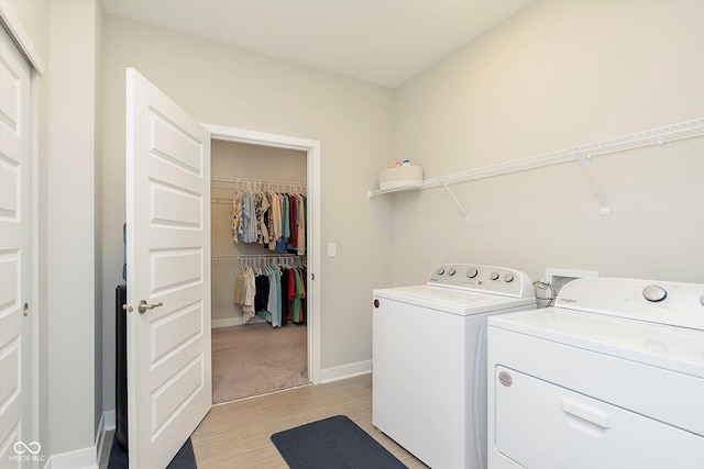 laundry room with laundry area, baseboards, washing machine and dryer, and light wood-style floors