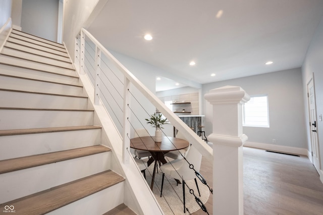 staircase featuring baseboards, recessed lighting, and wood finished floors